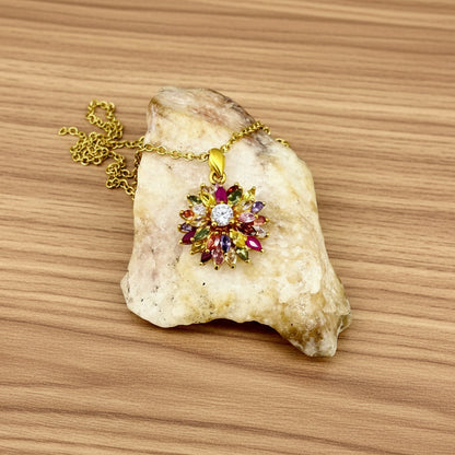 Gold-plated silver pendant with natural fancy sapphires and a central ruby in a floral arrangement.