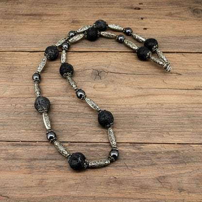 Handcrafted lava and hematite beaded necklace, 58 cm, in black and metallic tones.