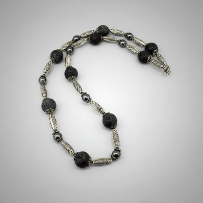Handcrafted lava and hematite beaded necklace, 58 cm, in black and metallic tones.