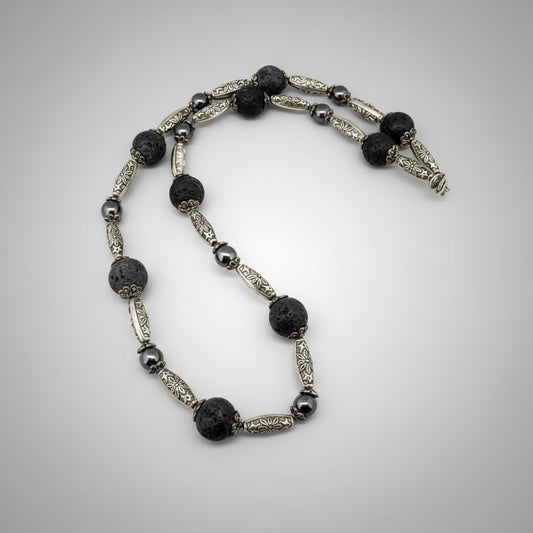 Handcrafted lava and hematite beaded necklace, 58 cm, in black and metallic tones.