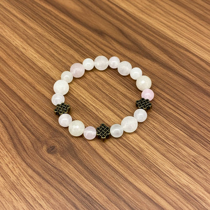 Rose quartz beaded jewelry set with golden spacers, including necklace with pendant, bracelet, and earrings in soft pink tones.