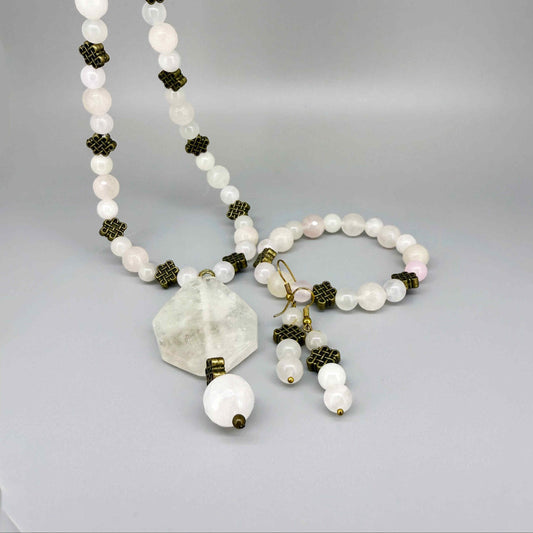 Rose quartz beaded jewelry set with golden spacers, including necklace with pendant, bracelet, and earrings in soft pink tones.
