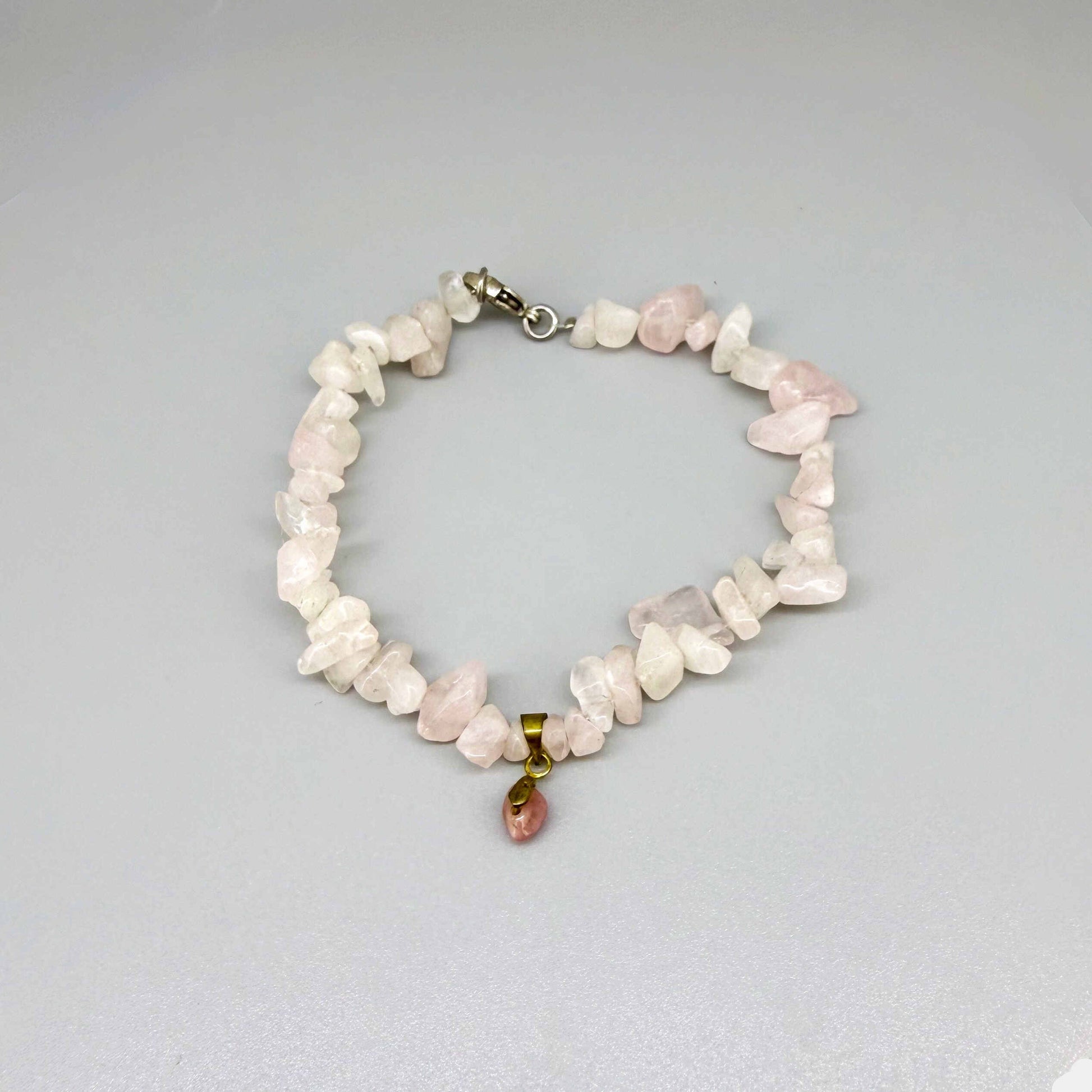 Rose quartz jewelry set with necklace, bracelet, and earrings in soft pink and gold tones, handcrafted with natural rose quartz beads.