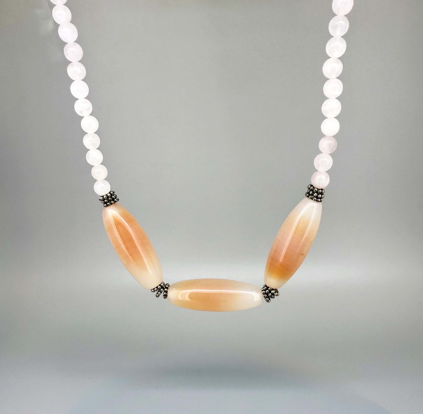 Rose quartz necklace and bracelet set, featuring soft pink beads with peach-toned accent stones, necklace 46 cm / 18.1 in, bracelet 17 cm / 6.7 in.