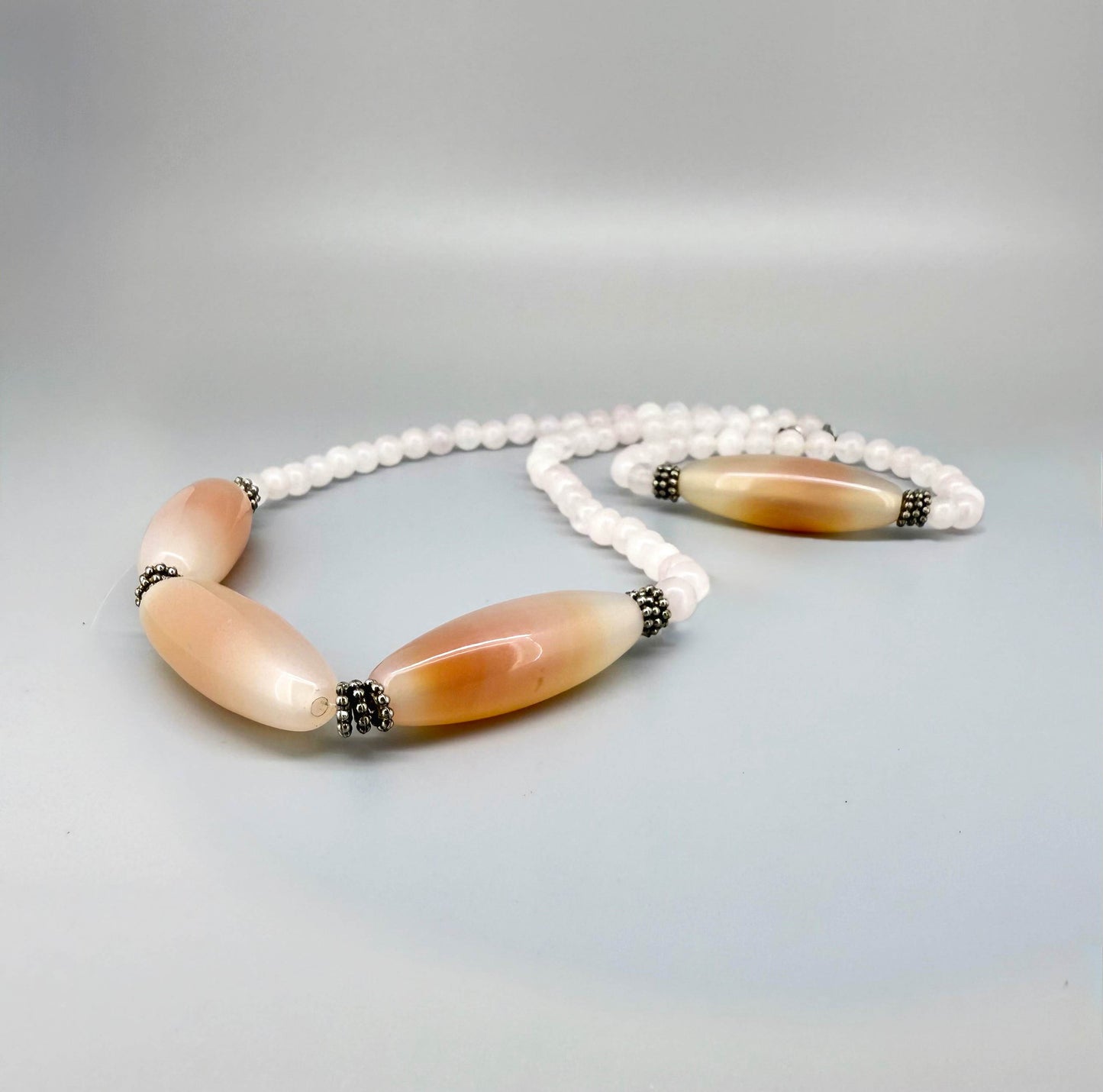 Rose quartz necklace and bracelet set, featuring soft pink beads with peach-toned accent stones, necklace 46 cm / 18.1 in, bracelet 17 cm / 6.7 in.