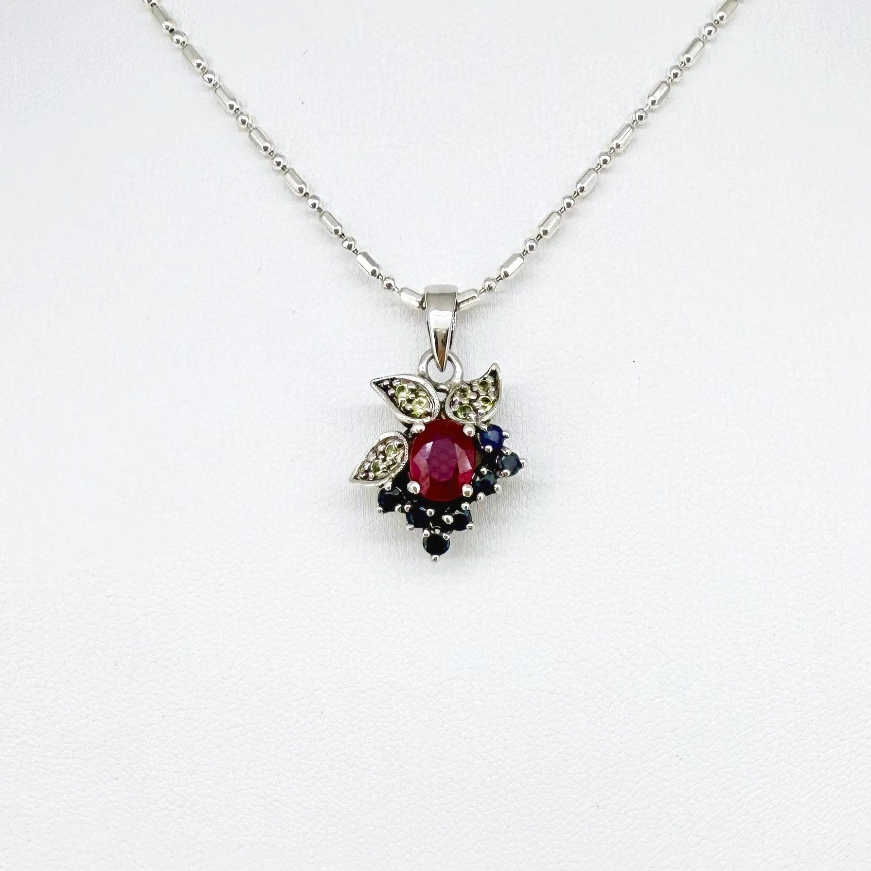 Handcrafted pendant with ruby (1.22 ct), sapphires (0.41 ct) and peridots (0.13 ct), set in white-gold-plated sterling silver.