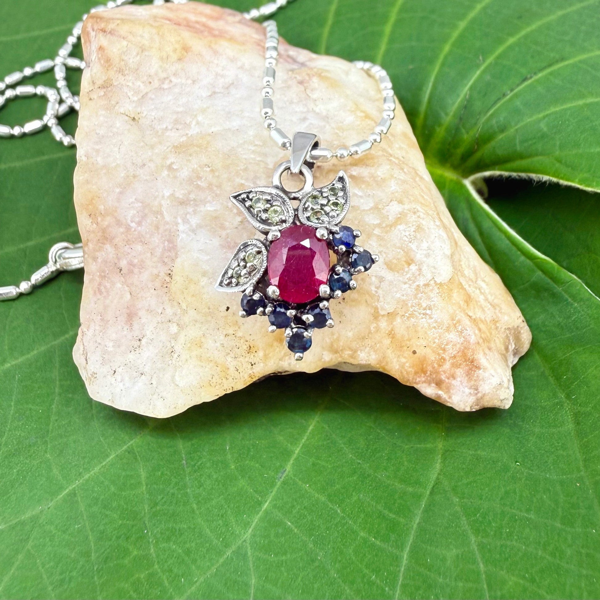 Handcrafted pendant with ruby (1.22 ct), sapphires (0.41 ct) and peridots (0.13 ct), set in white-gold-plated sterling silver.