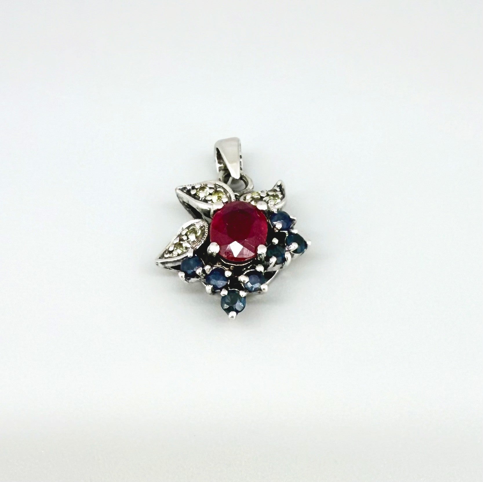 Handcrafted pendant with ruby (1.22 ct), sapphires (0.41 ct) and peridots (0.13 ct), set in white-gold-plated sterling silver.
