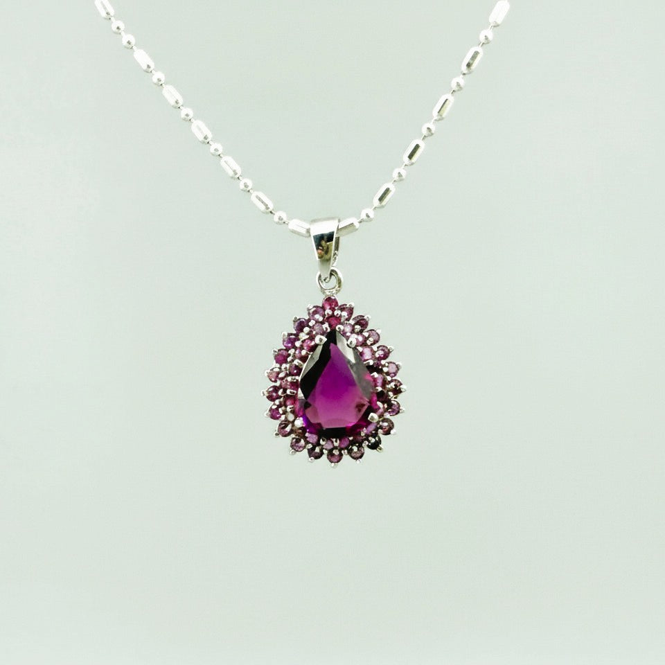Teardrop pendant with 3.4 ct rubellite tourmaline surrounded by natural rubies, set in white-gold-plated sterling silver.