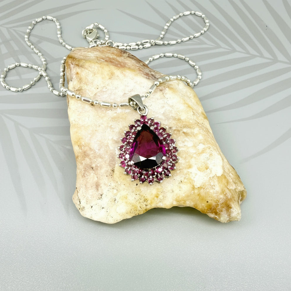 Teardrop pendant with 3.4 ct rubellite tourmaline surrounded by natural rubies, set in white-gold-plated sterling silver.