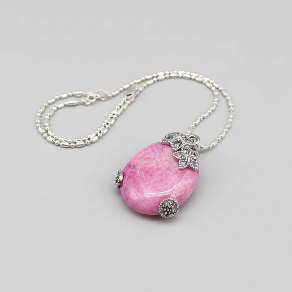 Handcrafted pendant with 46.3 ct natural ruby cabochon and 2.05 ct light blue sapphires in a white-gold-plated silver floral design.