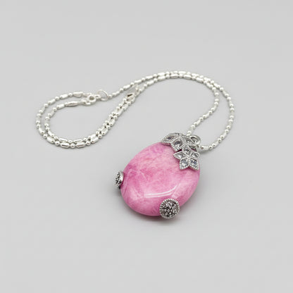 Handcrafted pendant with 46.3 ct natural ruby cabochon and 2.05 ct light blue sapphires in a white-gold-plated silver floral design.