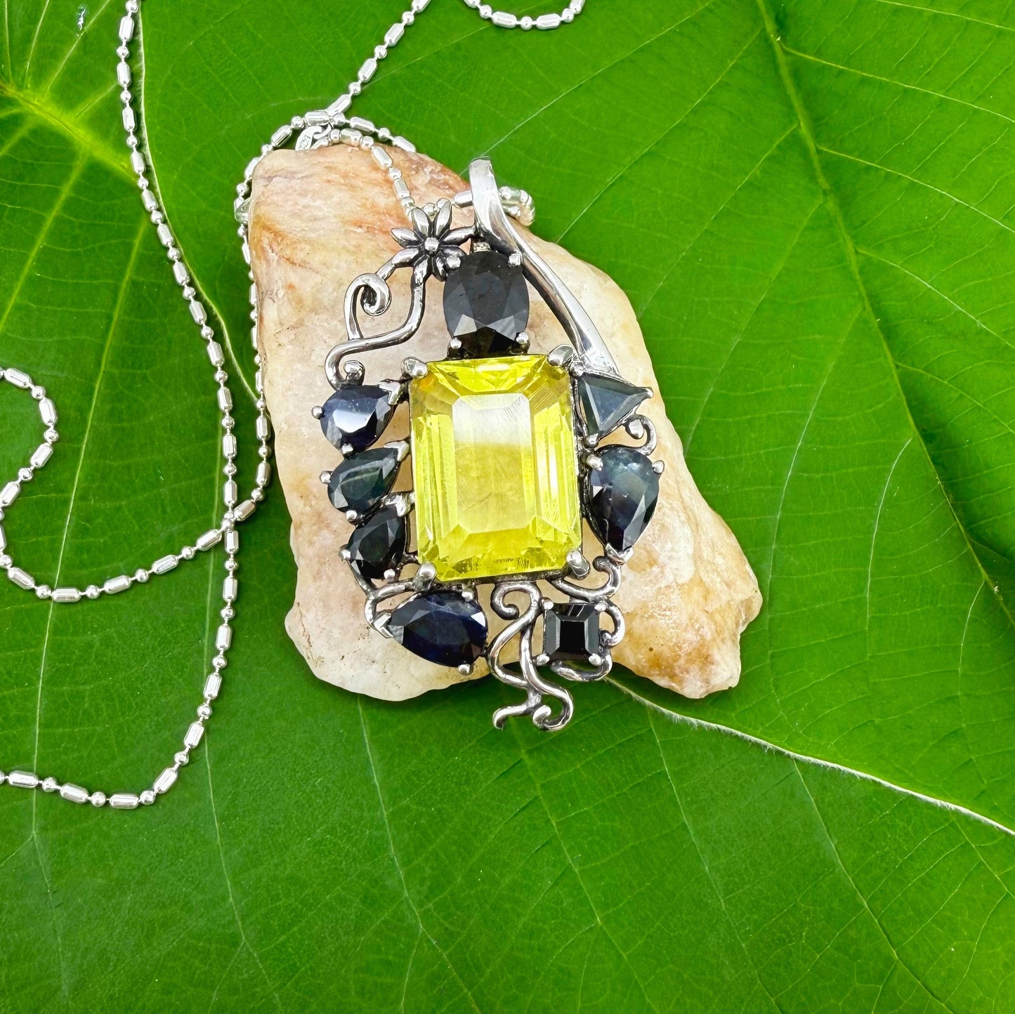 Handcrafted pendant with lemon quartz and blue sapphires set in white-gold-plated sterling silver.