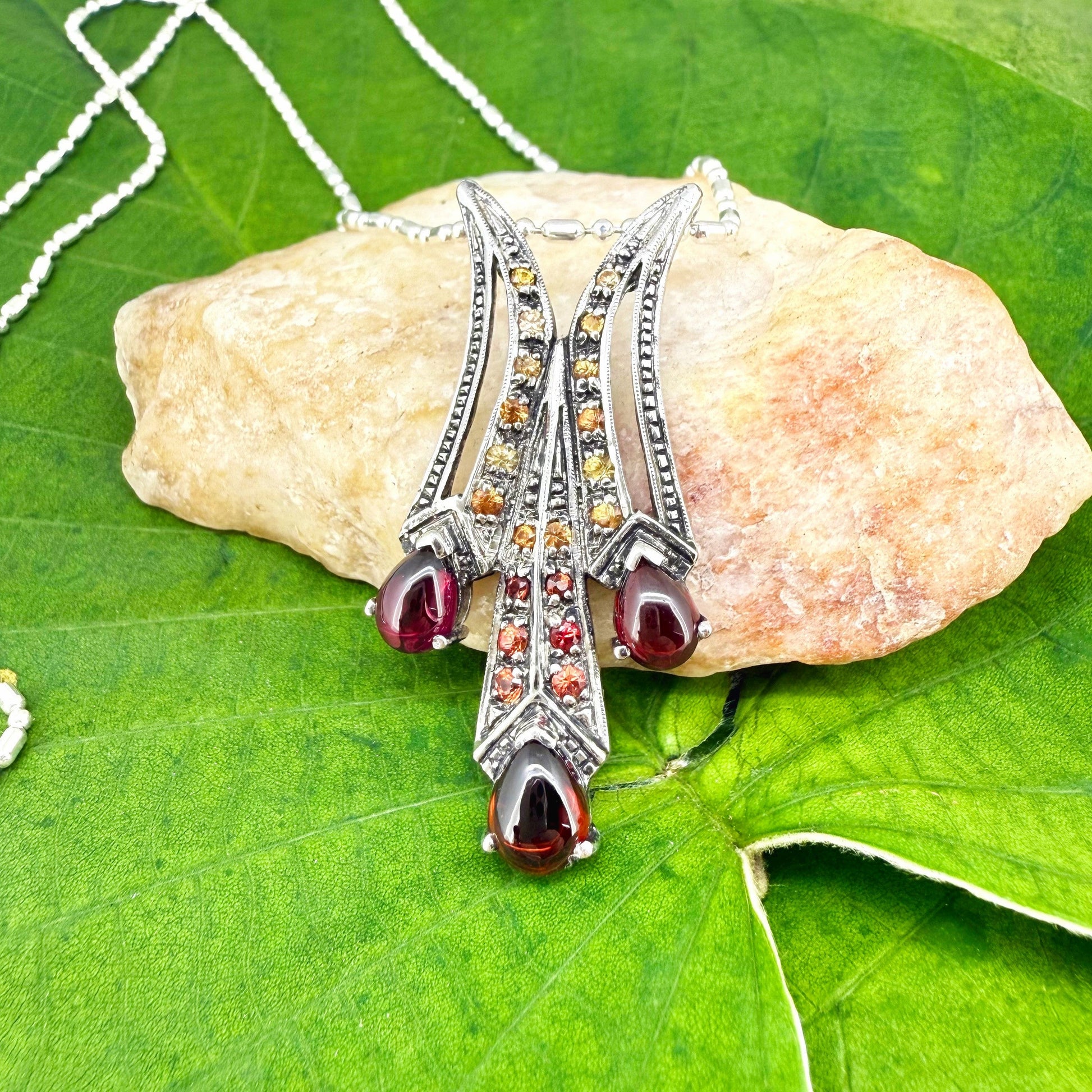 Handcrafted pendant with 3.6 ct garnets and multi-colored fancy sapphires set in white-gold-plated sterling silver.