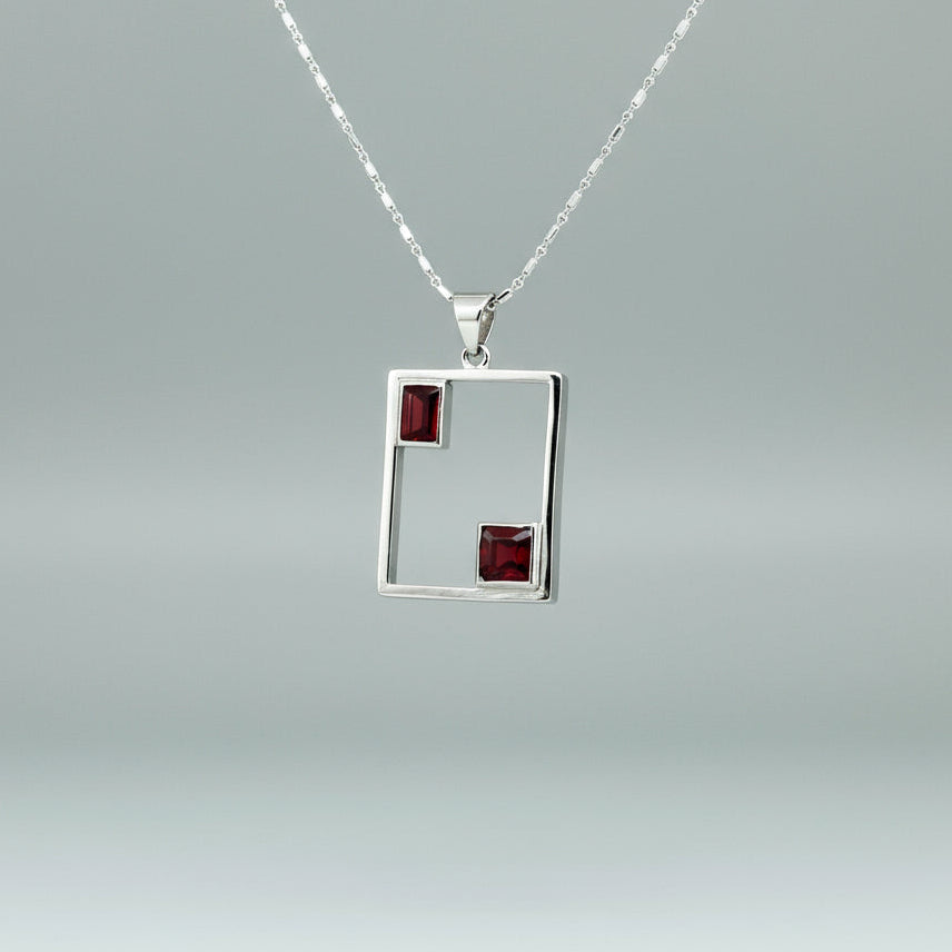 Modern handcrafted silver pendant with two natural rubies (3.24 ct total) set in an open square geometric frame.