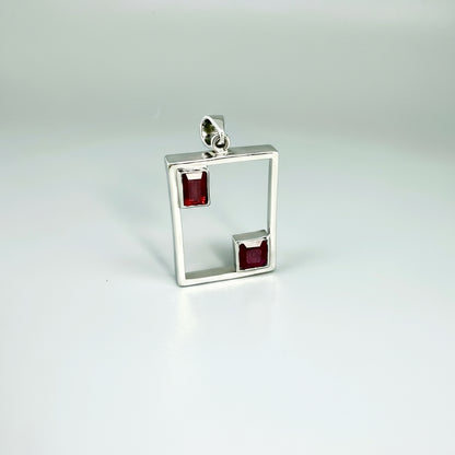 Modern handcrafted silver pendant with two natural rubies (3.24 ct total) set in an open square geometric frame.