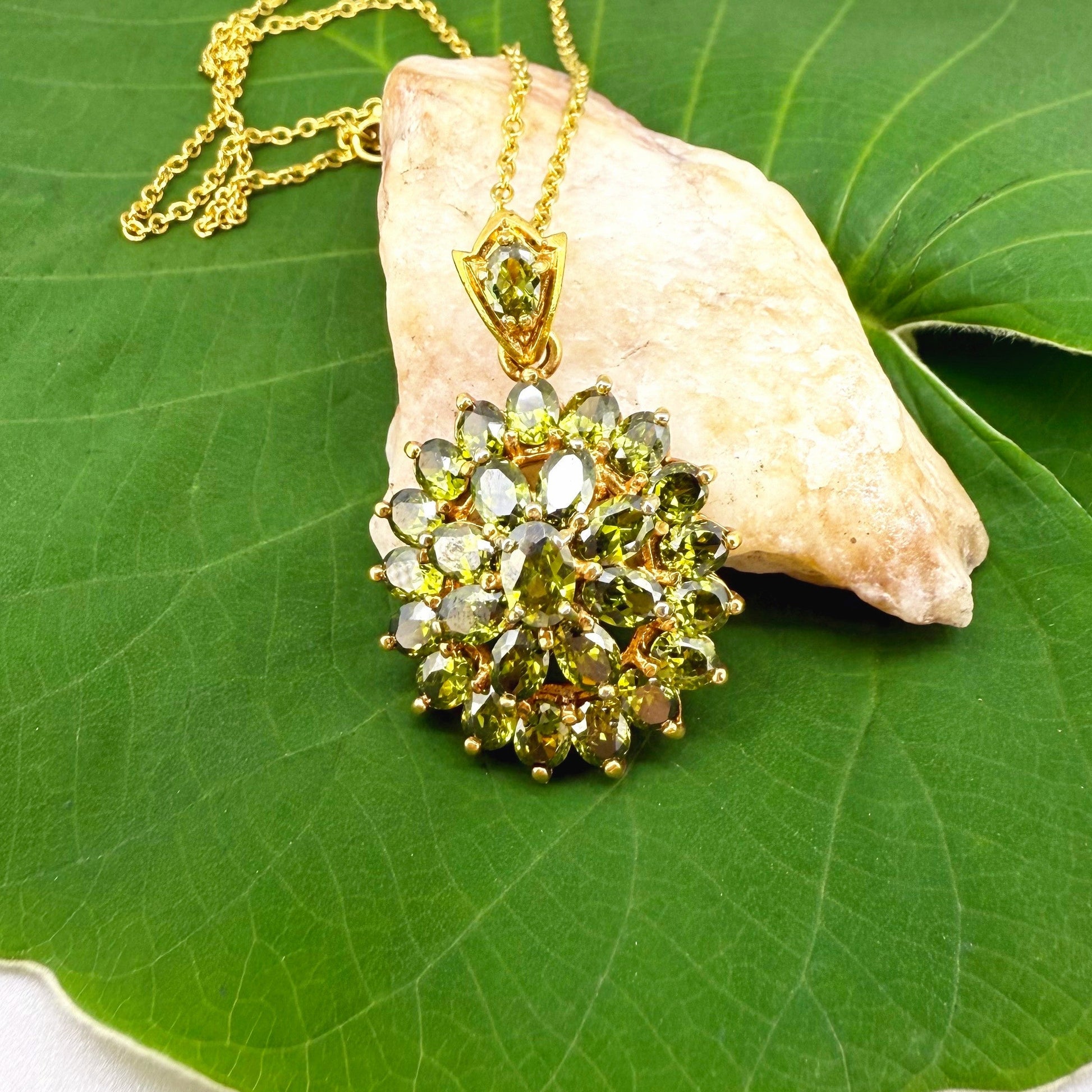 Gold-plated sterling silver pendant with natural green sapphires in a floral-inspired design.