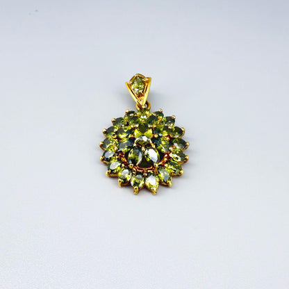 Gold-plated sterling silver pendant with natural green sapphires in a floral-inspired design.