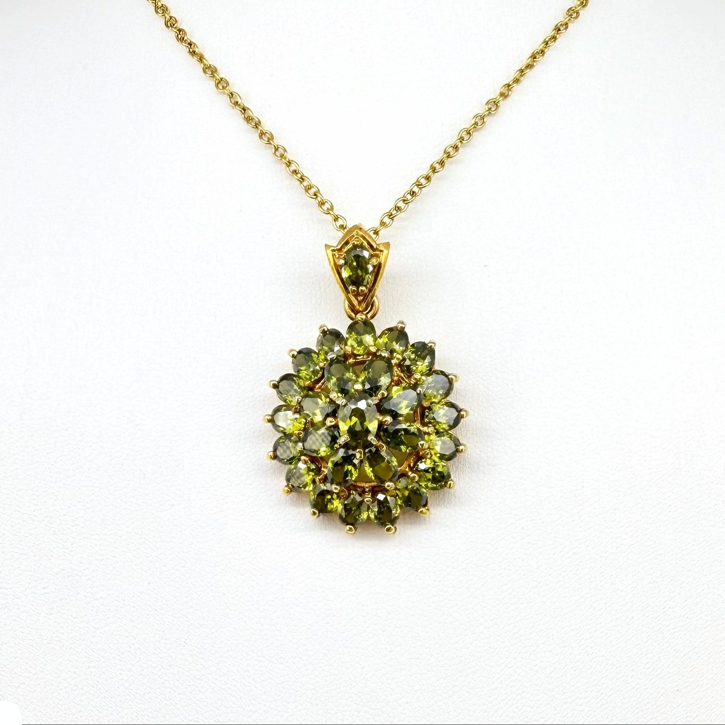 Gold-plated sterling silver pendant with natural green sapphires in a floral-inspired design.