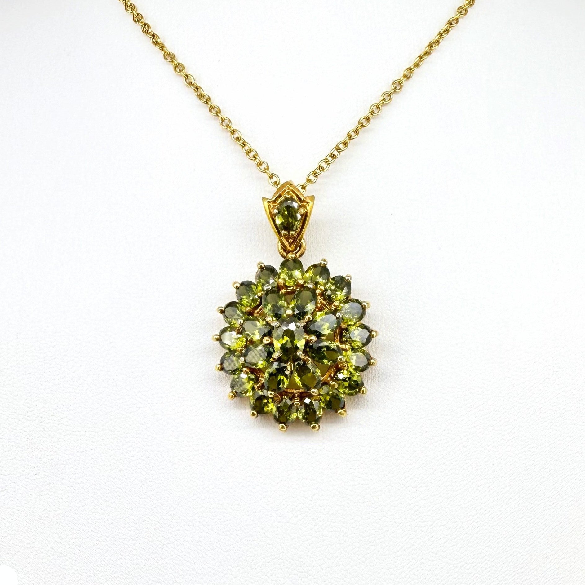 Gold-plated sterling silver pendant with natural green sapphires in a floral-inspired design.
