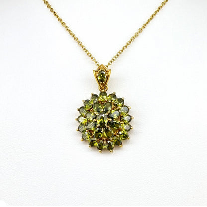 Gold-plated sterling silver pendant with natural green sapphires in a floral-inspired design.