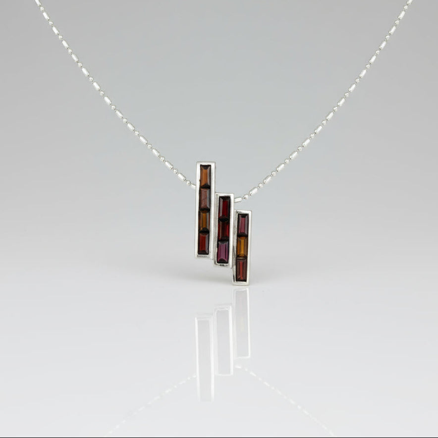 Handcrafted geometric pendant with 2.67 ct natural garnets set in sterling silver.