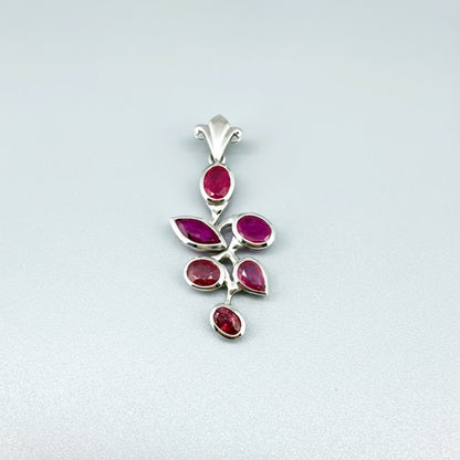 Handcrafted white-gold-plated silver pendant with 4.44 ct natural rubies in a floral design.