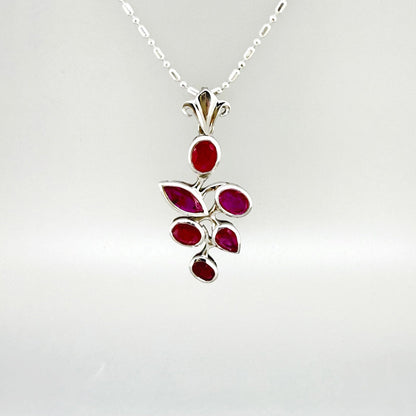 Handcrafted white-gold-plated silver pendant with 4.44 ct natural rubies in a floral design.