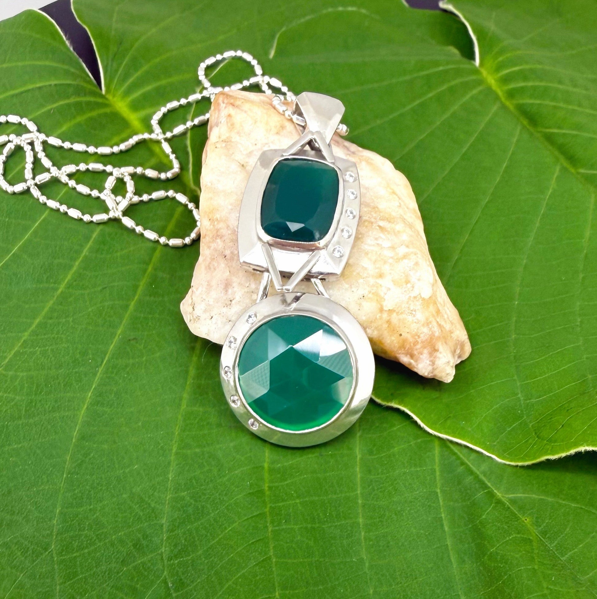 Handcrafted white-gold-plated silver pendant with two green chalcedony stones (16.47 ct total) in a modern geometric design.