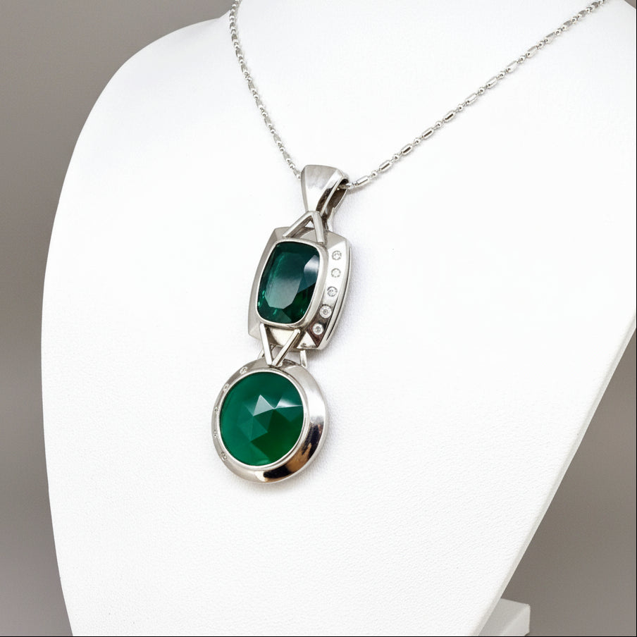 Handcrafted white-gold-plated silver pendant with two green chalcedony stones (16.47 ct total) in a modern geometric design.