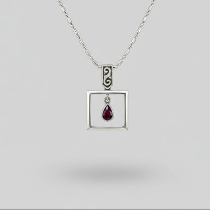 Handcrafted modern silver pendant with free-hanging teardrop ruby (0.55 ct) inside a square frame.