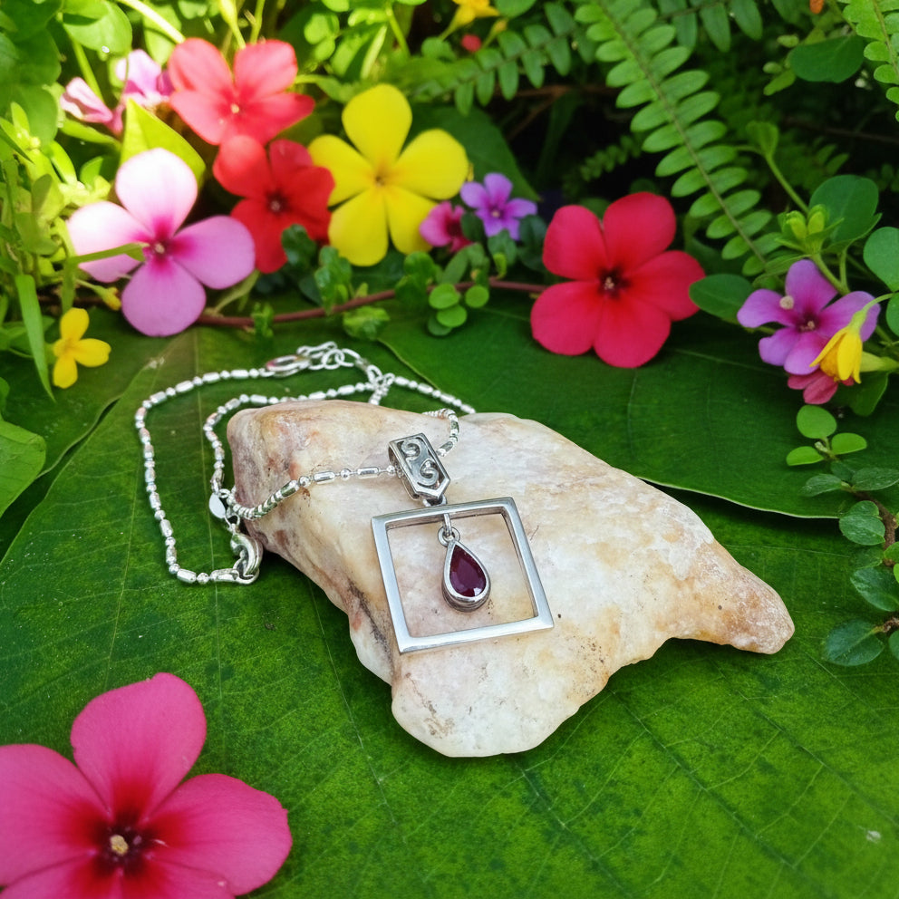 Handcrafted modern silver pendant with free-hanging teardrop ruby (0.55 ct) inside a square frame.