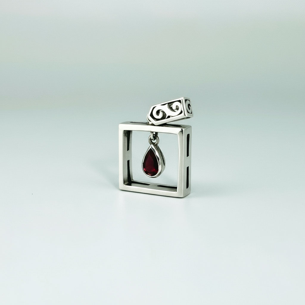 Handcrafted modern silver pendant with free-hanging teardrop ruby (0.55 ct) inside a square frame.