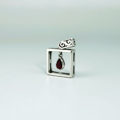 Handcrafted modern silver pendant with free-hanging teardrop ruby (0.55 ct) inside a square frame.