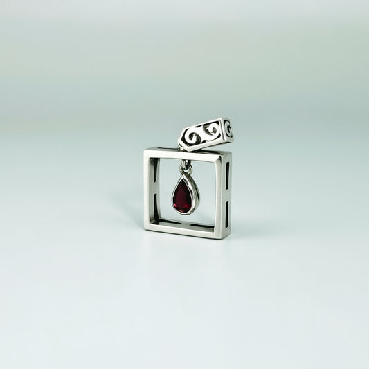 Handcrafted modern silver pendant with free-hanging teardrop ruby (0.55 ct) inside a square frame.