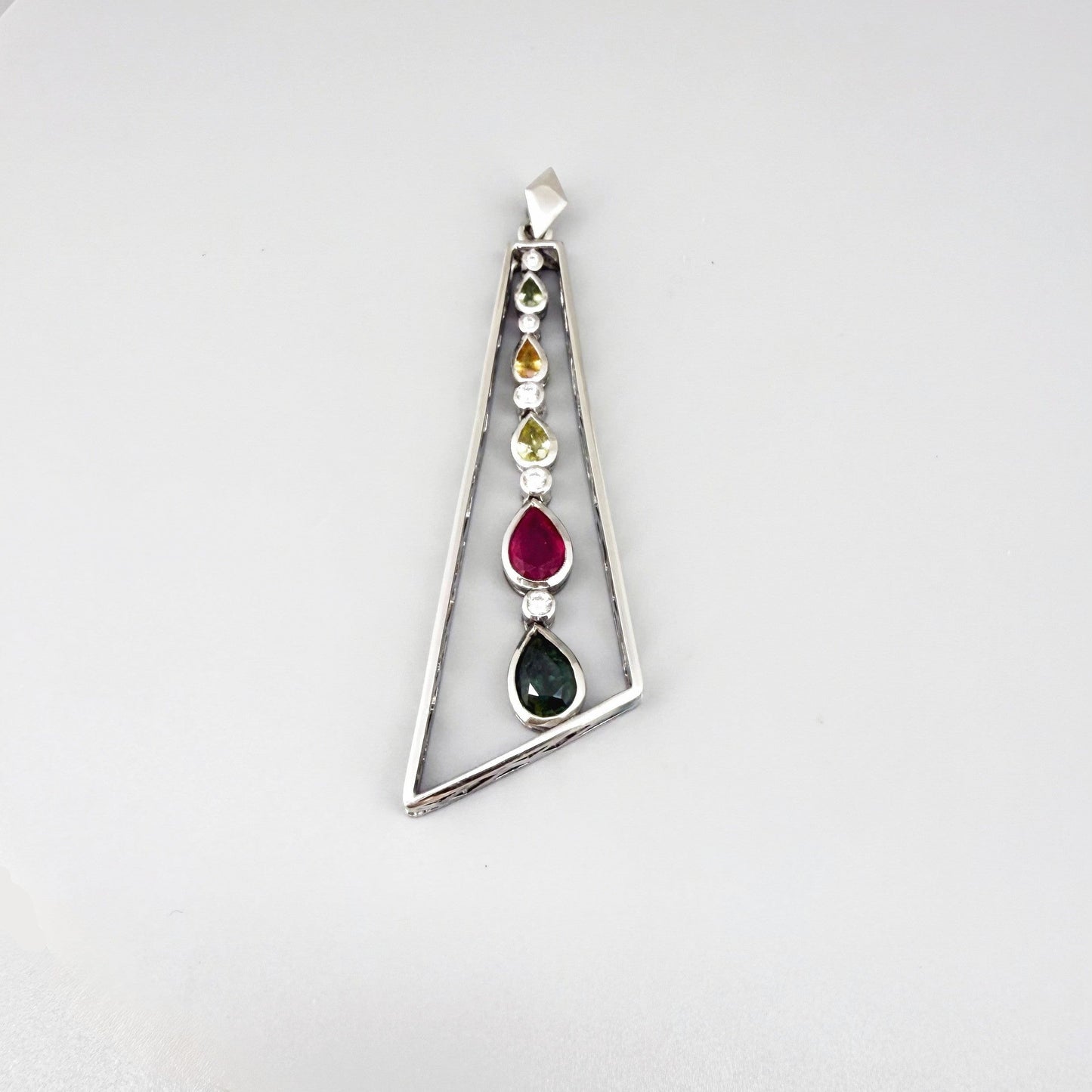 Handmade white gold plated silver pendant featuring 1.97 ct sapphires and 1.32 ct rubies in a modern geometric design with a freely moving gemstone strand.