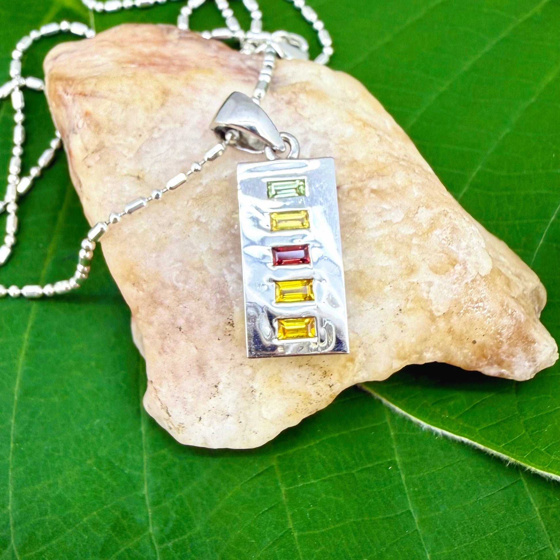 Handmade pendant featuring 0.8 ct fancy sapphires in yellow, pink, and blue, set in white-gold-plated sterling silver.