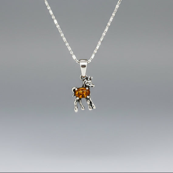 White-gold-plated silver horse pendant featuring a natural orange sapphire as the body.
