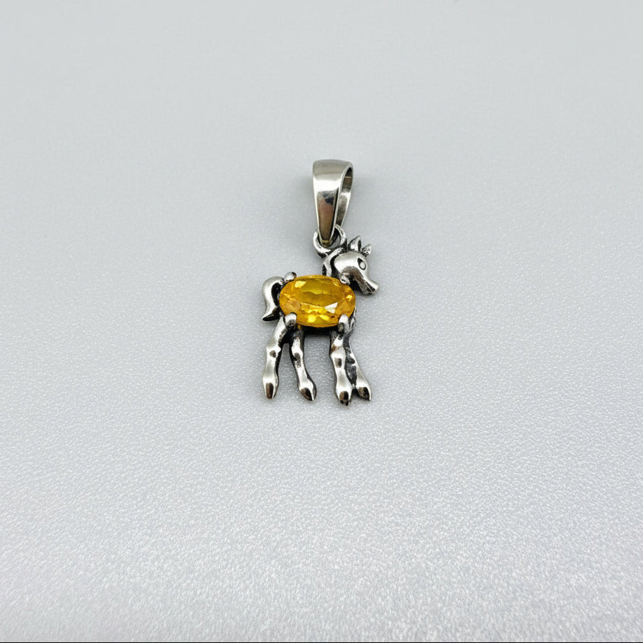 White-gold-plated silver horse pendant featuring a natural orange sapphire as the body.