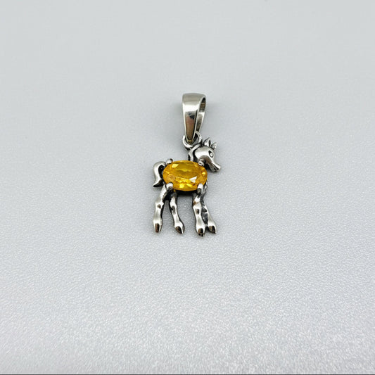 White-gold-plated silver horse pendant featuring a natural orange sapphire as the body.
