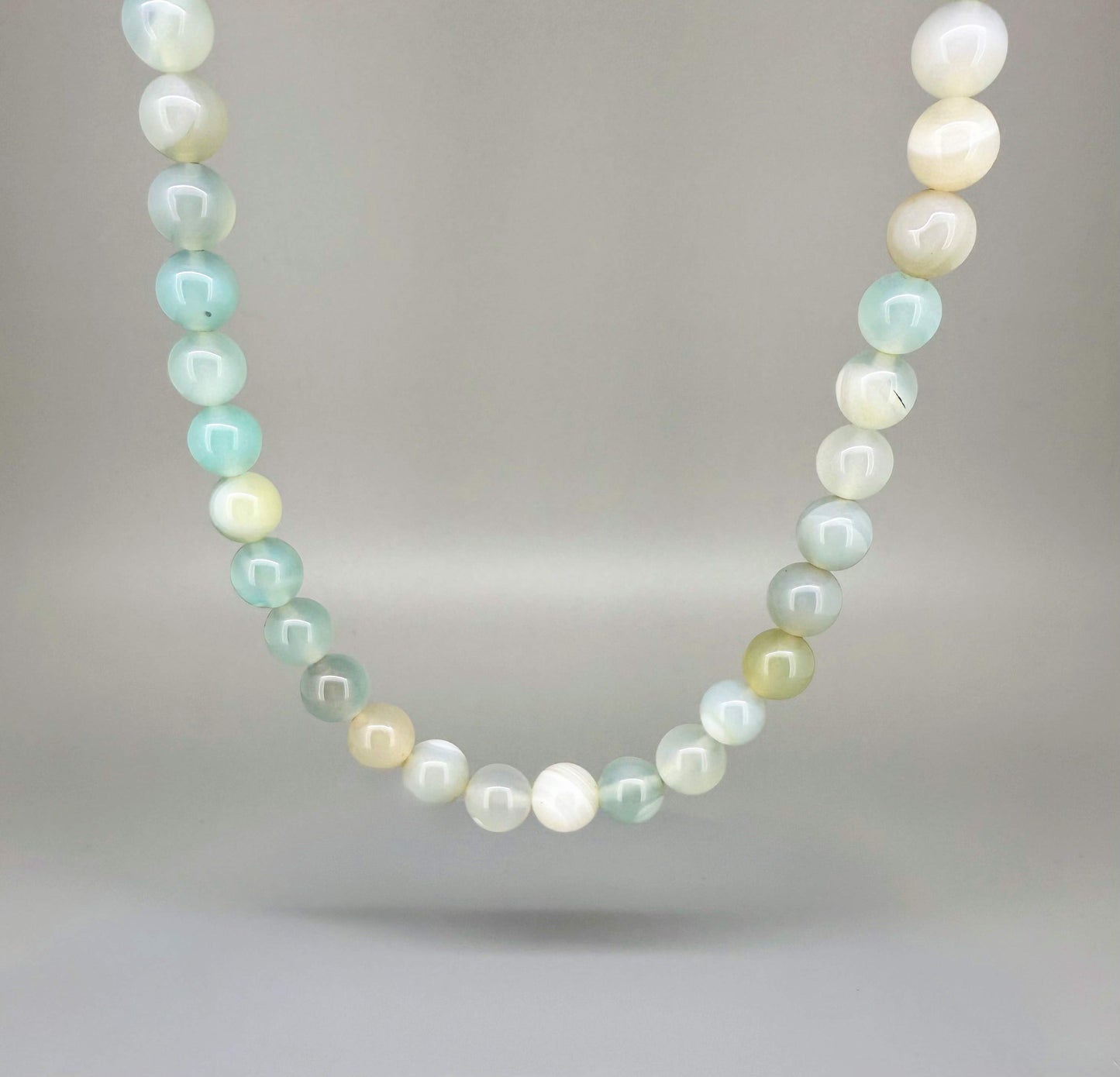 Agate necklace, 46 cm / 18.1 in long, featuring round pastel-toned agate beads in light green and cream.