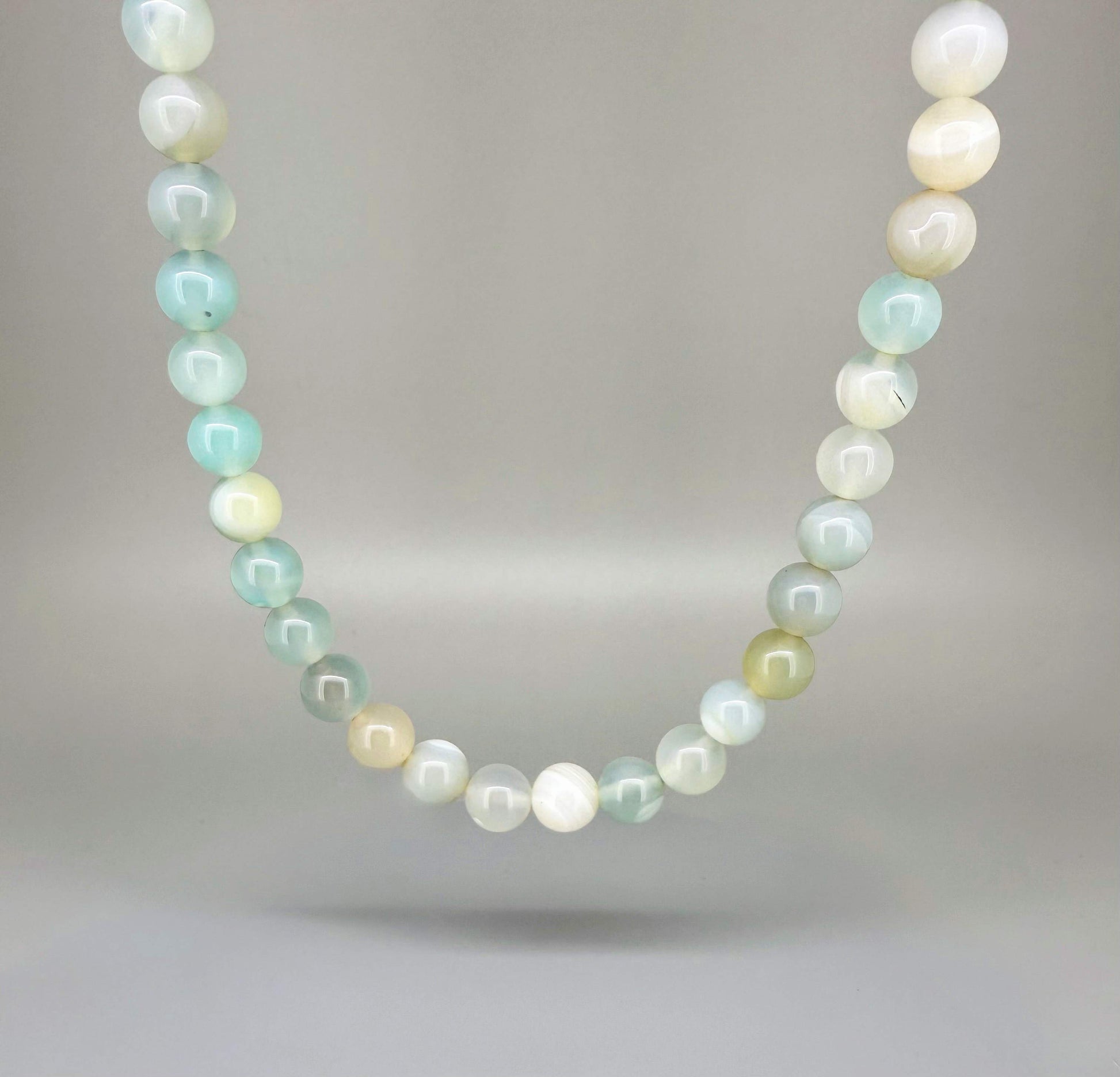 Agate necklace, 46 cm / 18.1 in long, featuring round pastel-toned agate beads in light green and cream.