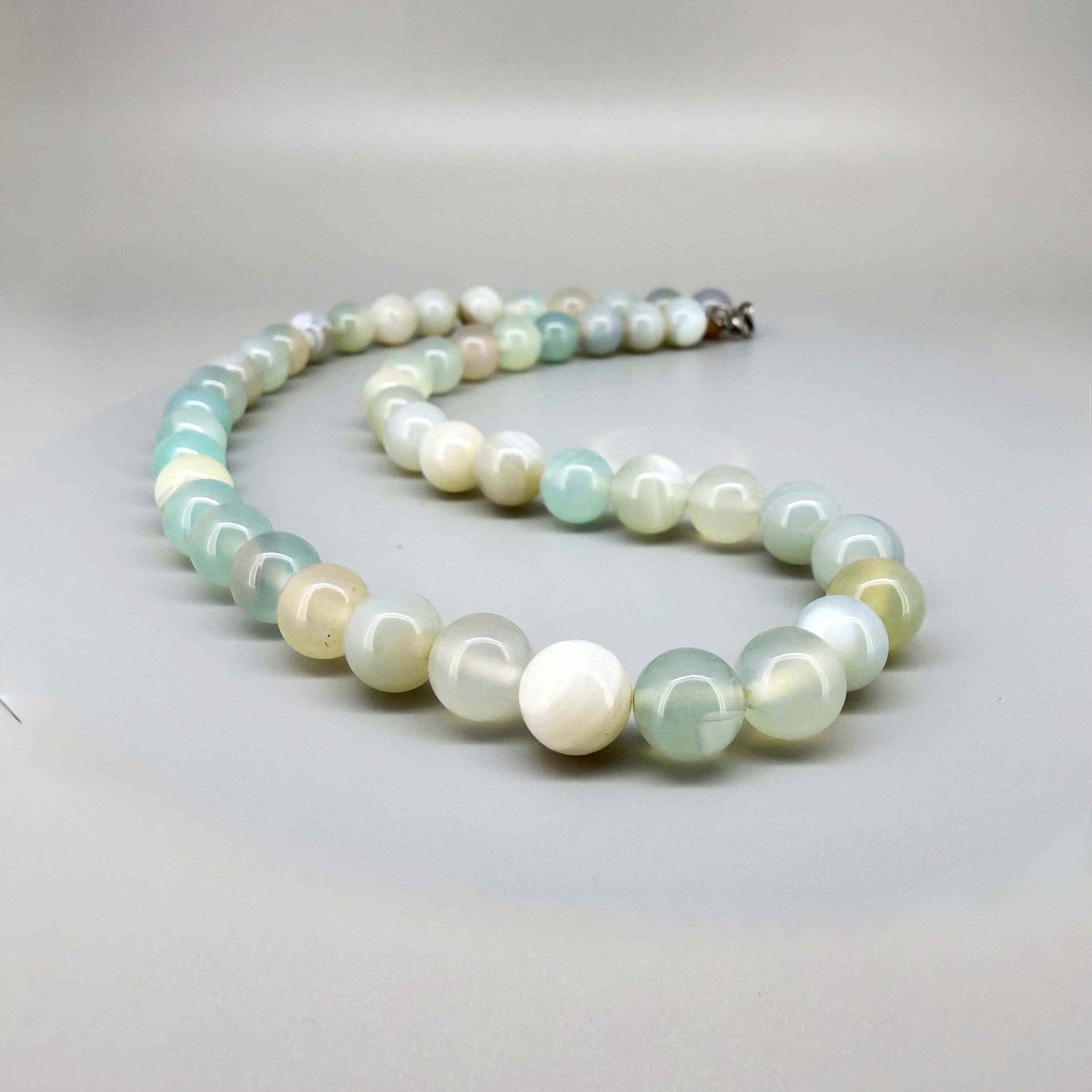 Agate necklace, 46 cm / 18.1 in long, featuring round pastel-toned agate beads in light green and cream.