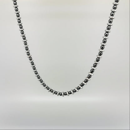 Hematite beaded necklace, 42 cm / 16.5 in long, featuring metallic silver-grey disc-shaped beads on a wooden background.
