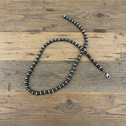 Hematite beaded necklace, 42 cm / 16.5 in long, featuring metallic silver-grey disc-shaped beads on a wooden background.