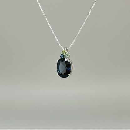 Elegant white gold plated silver pendant with 12.87 ct natural sapphires — one large central gem and three smaller accent stones.