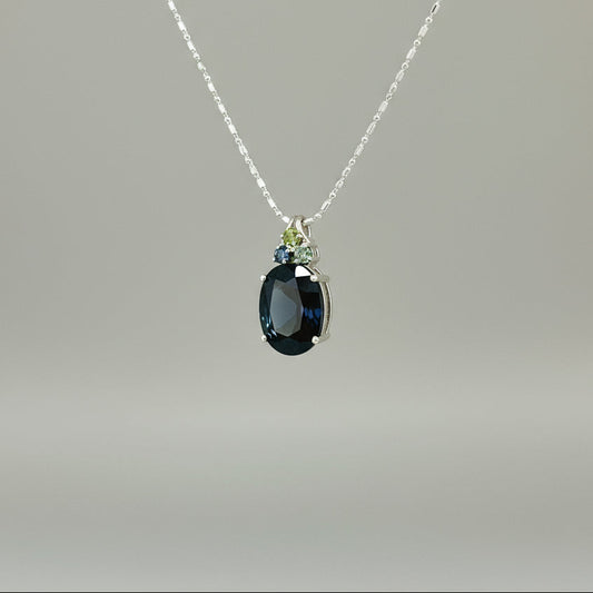 Elegant white gold plated silver pendant with 12.87 ct natural sapphires — one large central gem and three smaller accent stones.