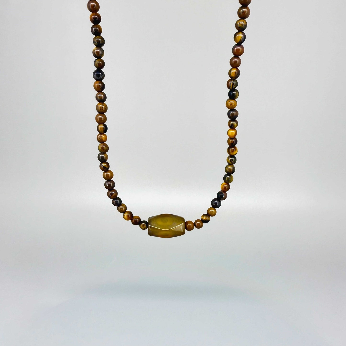 Tiger’s eye beaded necklace, 20 cm / 7.9 in long, featuring golden-brown stones and a central oval tiger’s eye bead.