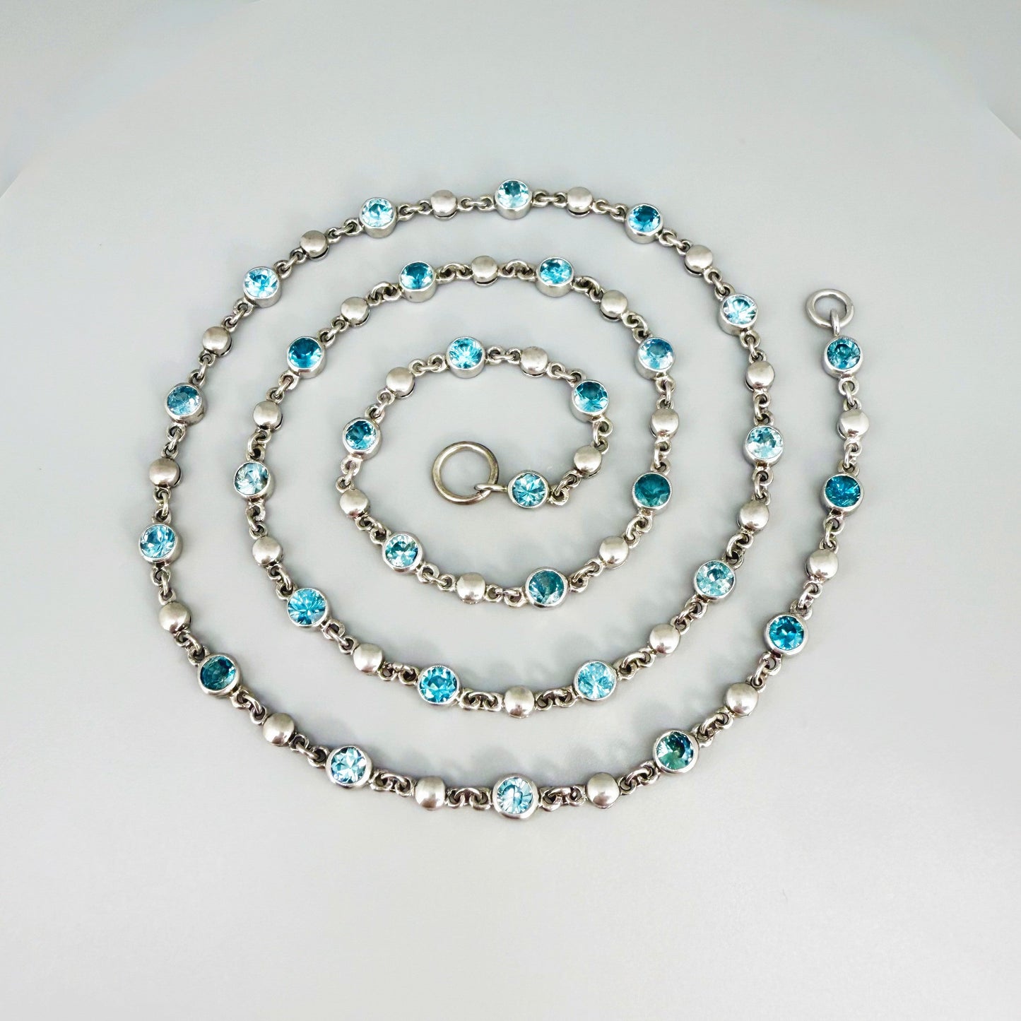 Handcrafted zircon necklace (19 ct) with adjustable loop clasp, wearable along the back or décolleté, white-gold-plated silver.