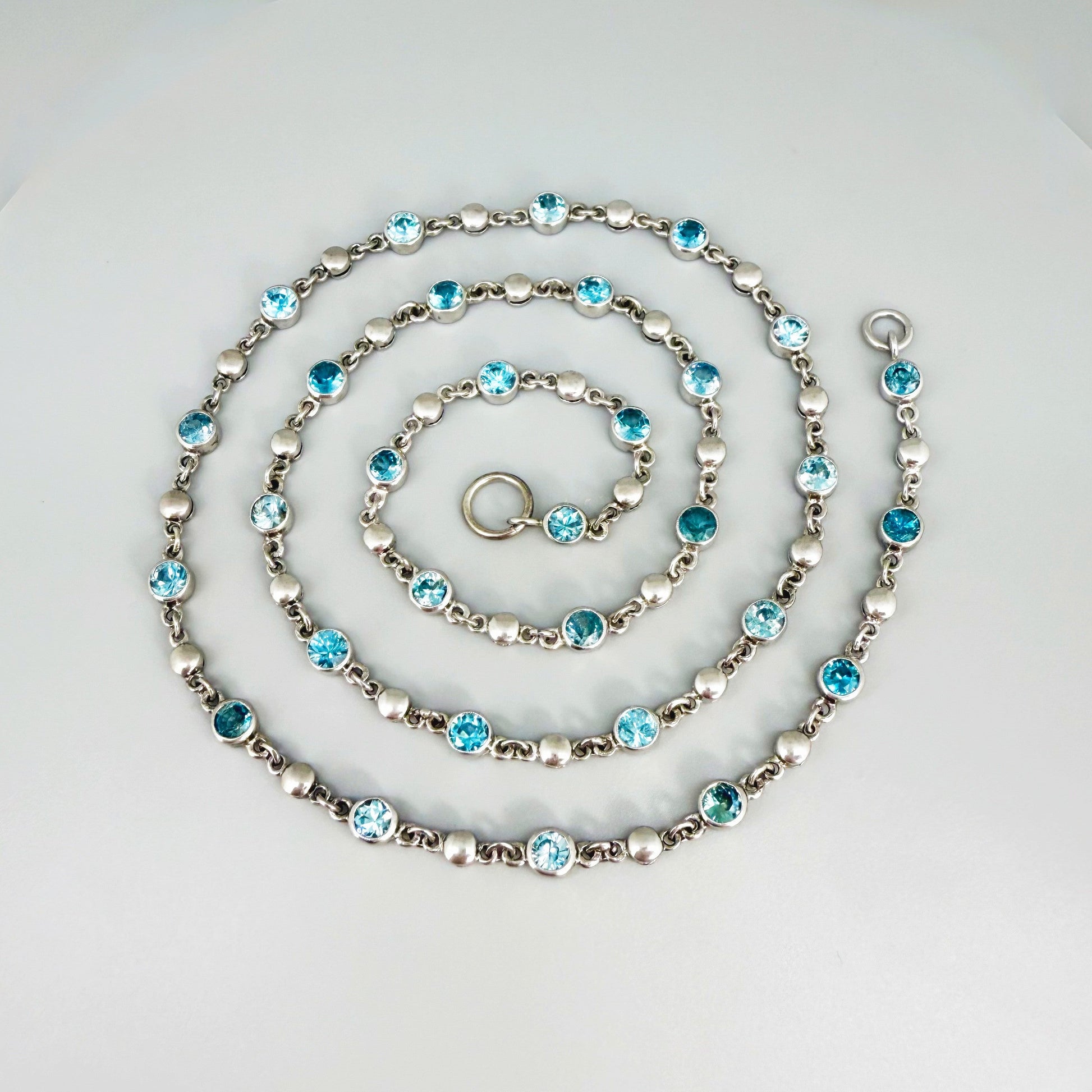 Handcrafted zircon necklace (19 ct) with adjustable loop clasp, wearable along the back or décolleté, white-gold-plated silver.